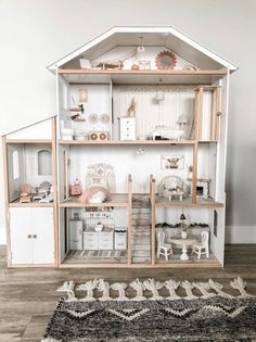 a doll house with all the furniture and accessories on display in front of a white wall