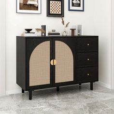 a black and beige cabinet with pictures on the wall