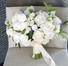 a bouquet of white flowers sitting on top of a chair