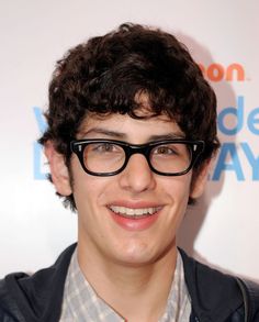 a young man with glasses smiling at the camera