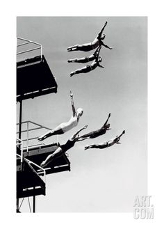 three men diving off the top of a lifeguard tower into the water from below