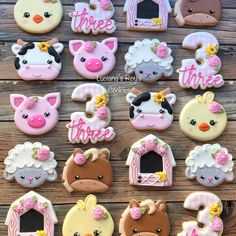 some decorated cookies with farm animals and sheeps on top of each cookie, along with the words three