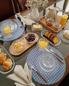 the table is set with breakfast foods and drinks