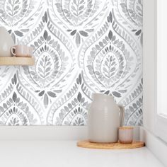 a white and grey wallpaper in a kitchen with two vases on the counter