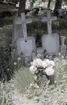 an old cemetery with several headstones and flowers