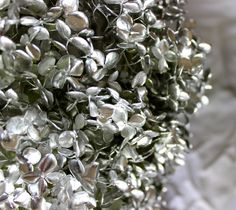 a bunch of small silver flowers sitting on top of a bed