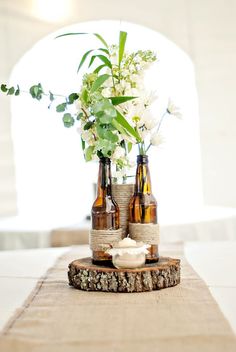 three bottles with flowers in them sitting on a table