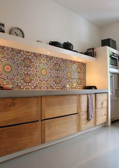 a kitchen with wooden cabinets and a clock on the wall above it's counter