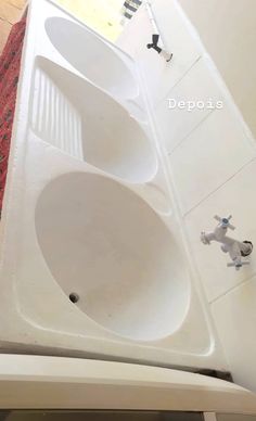 a white bath tub sitting on top of a bathroom floor next to a sink and mirror