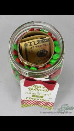 a jar filled with candy and money sitting on top of a table