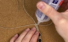 a person is using glue to attach something on the floor with their hands and fingers