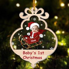 a baby's 1st christmas ornament hanging from a tree