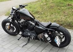 a black motorcycle parked on top of a sidewalk