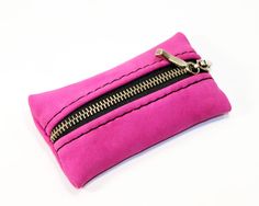 a pink zippered pouch sitting on top of a white table