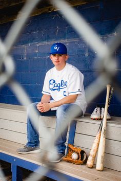 a baseball player sitting on a bench with his bat