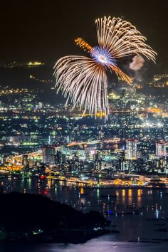 fireworks are lit up in the night sky over a city