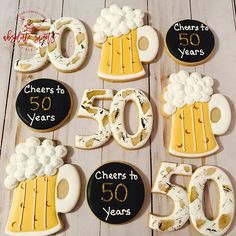 decorated cookies are arranged in the shape of beer mugs and 50 year anniversary numbers