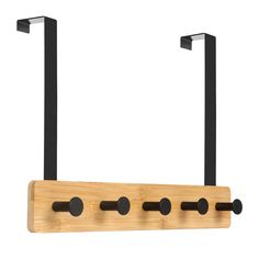 a wooden rack with black handles and two hooks on the back of it, hanging from a wall