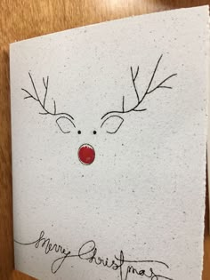 a handwritten christmas card with a reindeer's nose and antlers on it