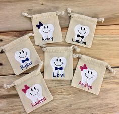 four personalized halloween treat bags with ghost faces and bow ties, on wooden background