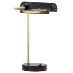 a black and gold desk lamp on a white background, with the light turned on