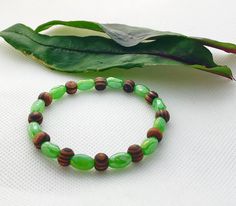 * This bracelet is made with opaque green glass beads with small amber natural wood beads. * Fits adult size (7-8 inches around with stretchy cord) * the perfect brown and green color combo! Adjustable bracelet to fit comfortably on your wrist! Cheap Green Beaded Braided Bracelets, Bracelet Layering, Green Bracelet, Brown Bracelet, Brown Jewelry, Wedding Jewelry Bracelets, Cord Bracelet, Layered Bracelets, Cord Bracelets