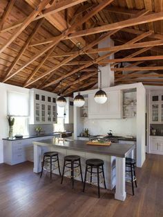 a large kitchen with an island and bar stools