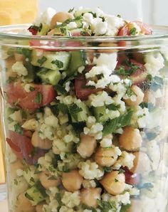 a glass jar filled with lots of different types of food on top of a table