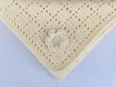 a white crocheted triangle with flowers on it