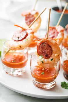 shrimp skewers with tomato sauce and parsley garnish on a white plate