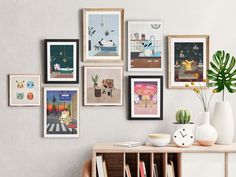 there are many pictures hanging on the wall next to a vase and potted plant