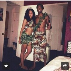 two people standing in front of a bed dressed up like hula skirt and leis