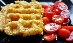 waffles and tomatoes on a black plate