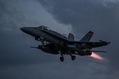 a fighter jet flying through a cloudy sky