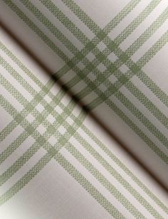 a green and white checkered wallpaper with a shadow on the wall behind it