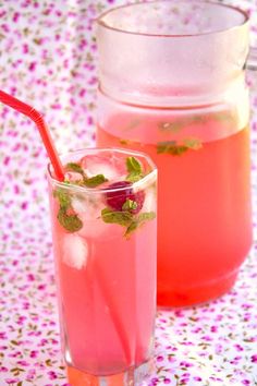 two glasses filled with drinks sitting next to each other on top of a floral table cloth