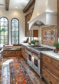 a large kitchen with wooden cabinets and an area rug on the floor in front of the stove