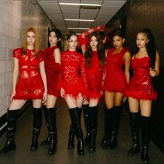 the models are all dressed up in red dresses and black knee high boots, posing for a photo