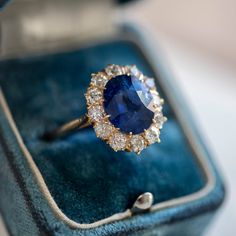 an oval blue sapphire and diamond ring in a velvet box