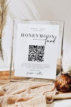 a glass frame with a qr code on it sitting next to some dried plants