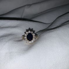 a diamond and sapphire ring on a white blanket