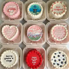 twelve decorated cupcakes in plastic trays with sayings on the top and bottom