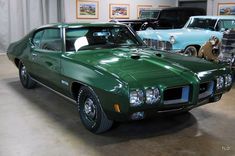 a green car parked in a garage next to other cars