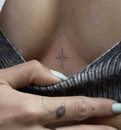 a woman's tattoo on her left breast is shown in this image, while the other hand has a cross tattooed on it