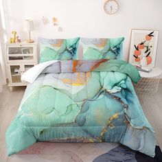 a bed covered in a blue and green comforter next to a white wall with a clock on it