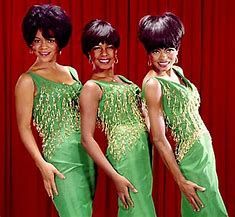 three women in green dresses standing next to each other