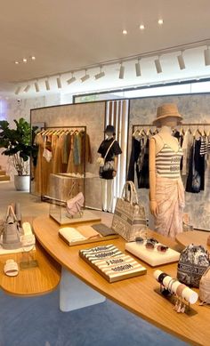 a women's clothing store with mannequins and handbags on display