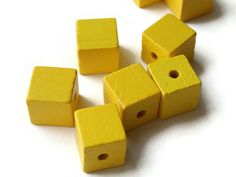 yellow cubes with holes in them on a white surface