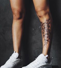 a woman's legs with tattoos on them and white tennis shoes in front of her