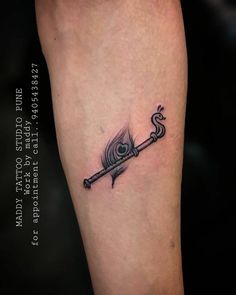 an arrow with a feather on it and a hook in the middle is tattooing